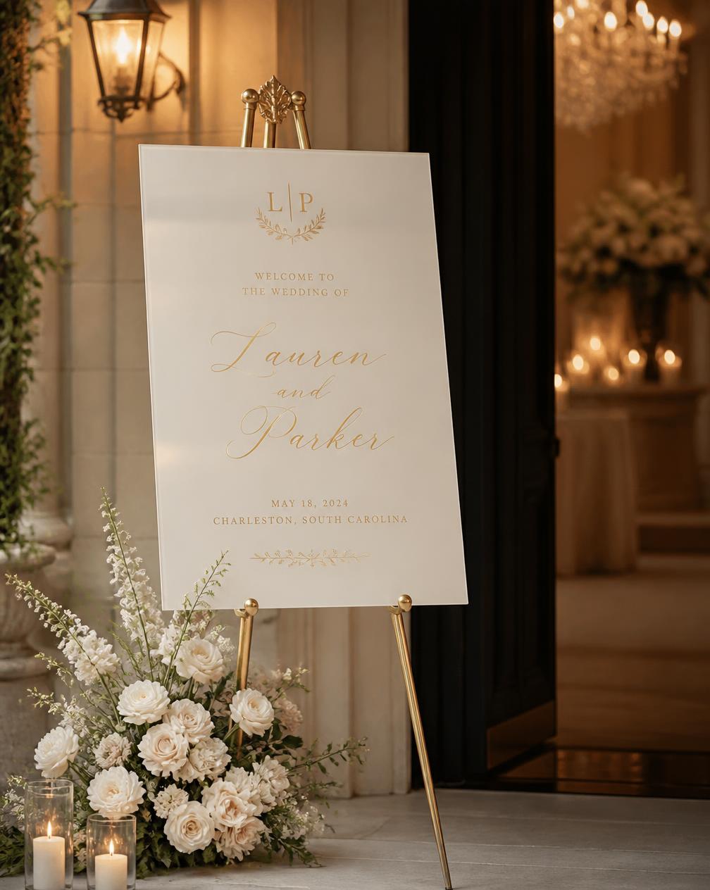 An ivory wedding welcome board on a gold easel